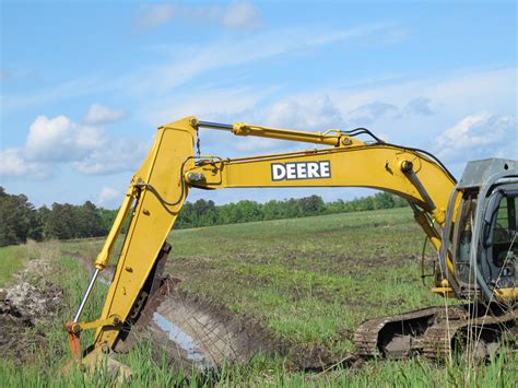 using a mini excavator for cleaning out a ditch|drainage ditch cleaning.